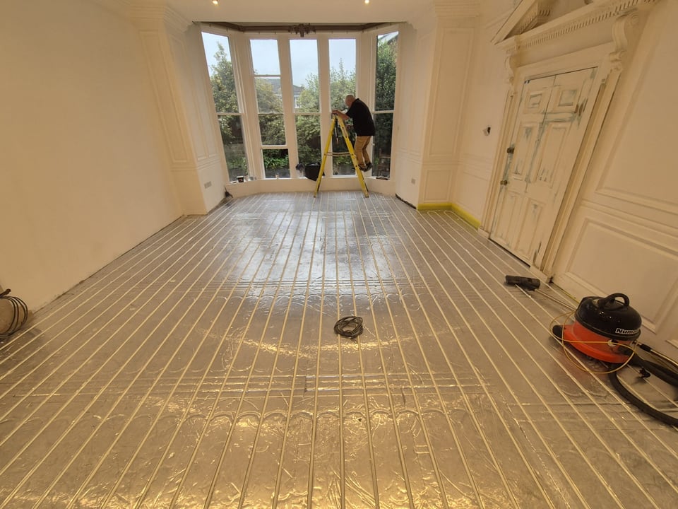 Underfloor heating pipework fitted across a large room during renovation
